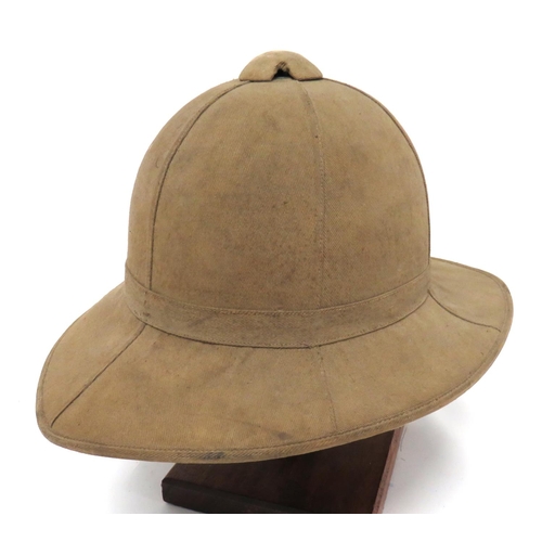 WW1 Pattern British OR's Pith Helmet
light khaki, six panel crown.  Pointed peak and square rear brim.  Single pagri band.  Green cotton lining.  Leather sweatband.  Inner sweatband with WD issue stamp.  Crown with various service numbers.  