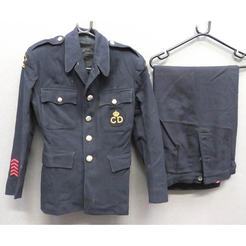WW2 ARP/CD Tunic And Slacks
consisting dark blue/black, single breasted tunic.  Patch chest pockets with buttoned flaps.  Lower hidden pockets with plain flaps.  Both arms with embroidery "Ambulance Driver" titles.  Lower right cuff with 5 red chevrons.  Left breast with embroidery KC "CD" patch.  White metal ARP buttons.  Internal label dated 1941 ... Matching dark blue/black, wide leg slacks. Side waist button fastening.  Some moth damage.  2 items.