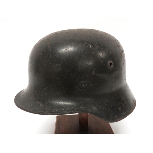 German Third Reich Luftwaffe Double Decal M1935 Steel Helmet
dark brown painted shell with lower rolled rim.  The left side with faint Luftwaffe eagle and swastika.  The right side with faint National shield.  Inner brim stamped "Q66" and "805". Alloy liner band and chinstrap loops.  Leather, 9 tongue liner.  Liner now dry.  Outer with minor surface rusting.  