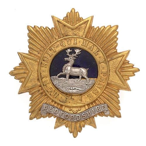 Bedfordshire Regiment Victorian post 1881 Officer’s forage cap badge.  Fine die-stamped gilt Maltese cross superimposed on eight pointed star bearing the Garter. To the blue enamel centre, a silver hart crossing a ford. Beneath the Garter, an applied silver scroll BEDFORDSHIRE.     Loops.  VGC
