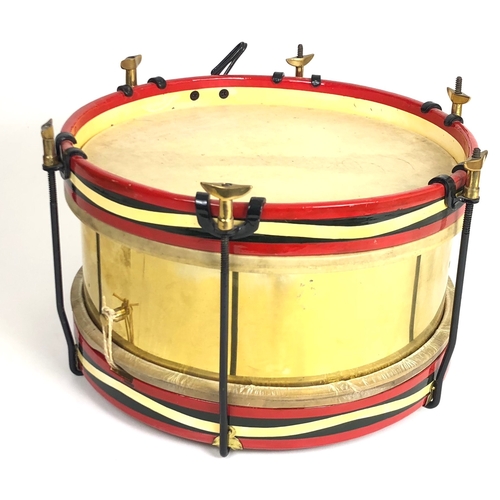 Miltary style snare drum  A good post war small rod tensioned unmarked brass example.  Complete with rims and skins.        The instrument’s accuracy is neither warranted or implied.