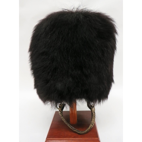 199 - Guards Pattern Busby
black fur body.  Inner wickerwork frame.  Black leather, eight tongue... 