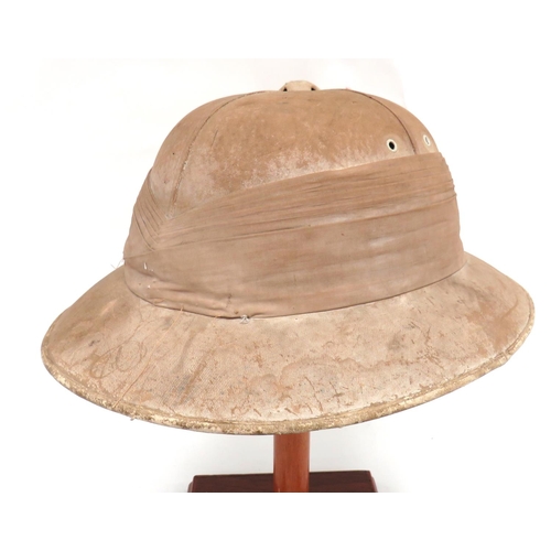 Early 20th Century Officer's Solar Pith Helmet
white blancoed, four panel crown.  Wide brim.  Multi fold linen pagri band.  Green linen underbrim and cream crown with "Hawkes & Co" maker's stamp.  Leather and Aertex sweatband.  Some wear.  