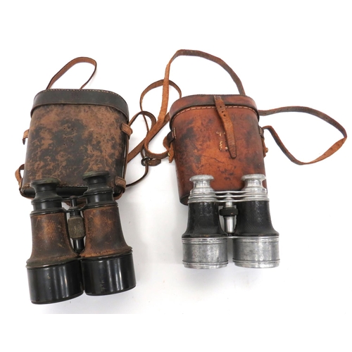 Two Pairs Of WW1 Period Field Binoculars
consisting pair of blackened brass, field binoculars.  Leather covered body.  "Paris" maker to the top.  Complete in their leather case ... Similar smaller pair in alloy with leather covered body.  Complete in their leather case.  2 items.