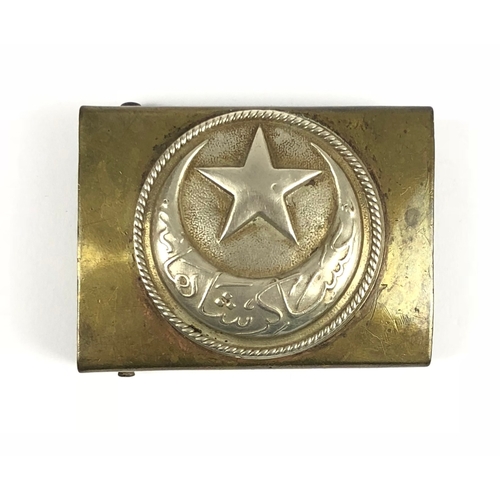 Otterman Empire M1909 WW1 Turkish belt buckle.  Good scarce rectangular brass issue with white metal beaded edge overlay bearing five pointed star and crescent. Complete with rolling bar bearing twin prongs and applied securing bar to reverse. Minor service wear. GC        PAYMENT, BY BANK TRANSFER ONLY, ON RECEIPT OF INVOICE.