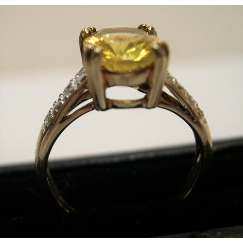 32 - 9ct gold and yellow stone ring in claw set mount with the sides set with diamonds, 

2.6 grams gross... 