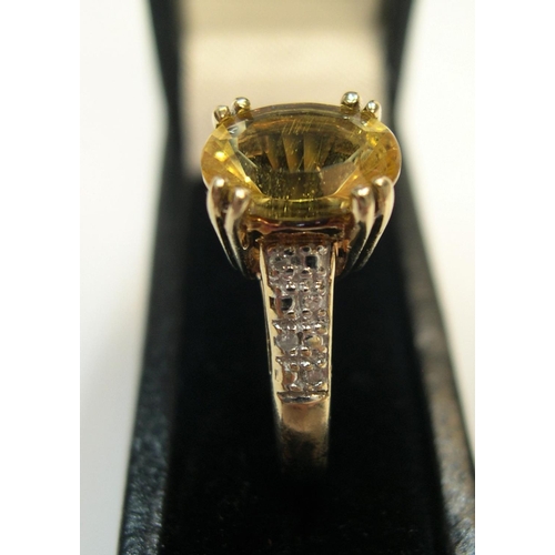 32 - 9ct gold and yellow stone ring in claw set mount with the sides set with diamonds, 

2.6 grams gross... 