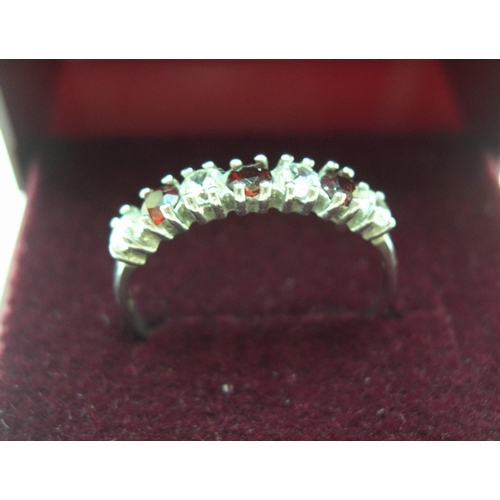 42 - 9ct white gold, half eternity ring with CZ & garnets

1.2 grams, gross,       size M