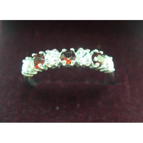 42 - 9ct white gold, half eternity ring with CZ & garnets

1.2 grams, gross,       size M