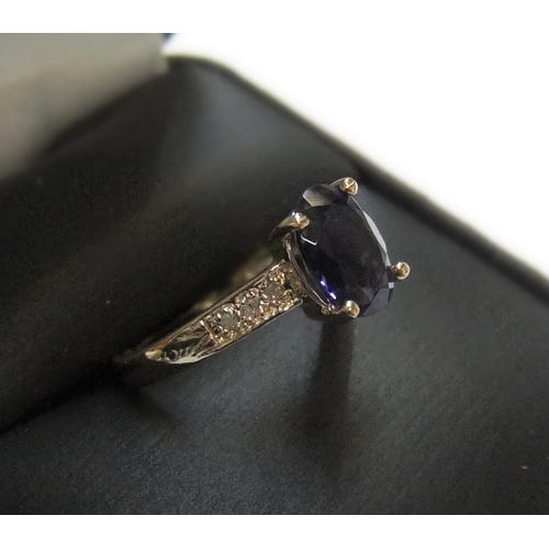 70 - 9ct yellow imported gold ring set with an oval cut iolite and with small diamonds set to the shoulde... 