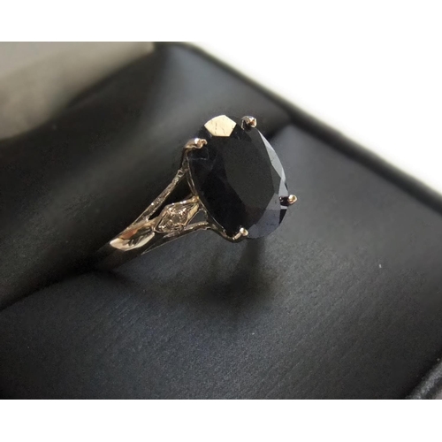 73 - 9ct yellow imported yellow gold ring set with a large black sapphire & with a small diamond set to e... 