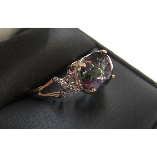 4 - 9ct yellow imported gold ring with a large oval cut mystic topaz with a small diamond to each should... 