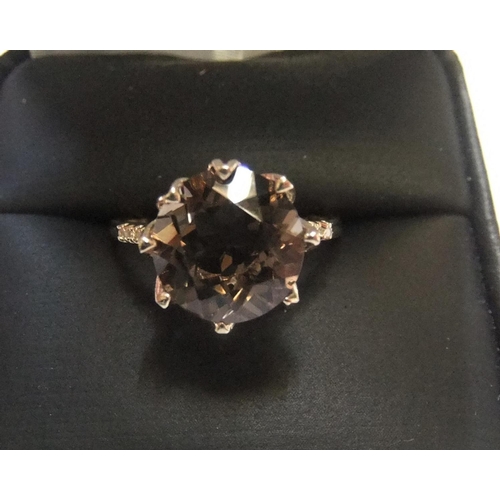 11 - 9ct yellow imported gold ring set with a large oval cut smokey topaz and with a small diamond set to... 