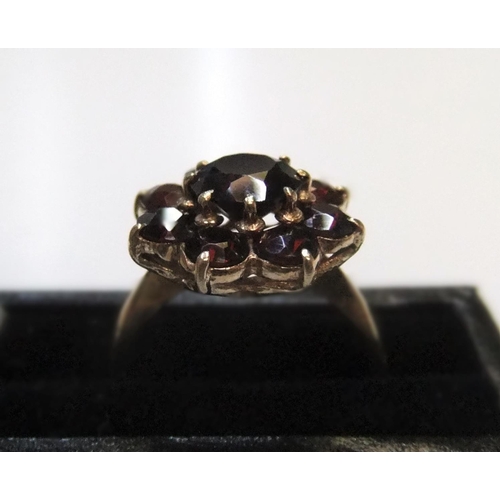 89 - 9ct yellow gold, garnet flower ring

Approx 4.3 grams gross,             size P