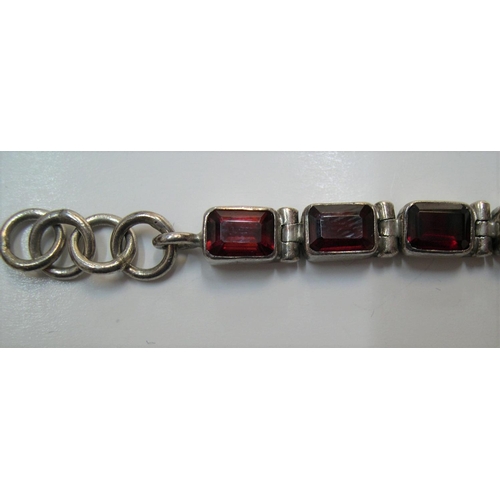 115 - Silver bracelet with red stone panels, 20cms long