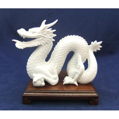 168 - Finely detailed, white fired ceramic dragon (unmarked) on chinese wood plinth,

21 cm long