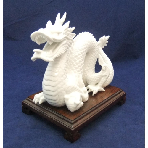 168 - Finely detailed, white fired ceramic dragon (unmarked) on chinese wood plinth,

21 cm long