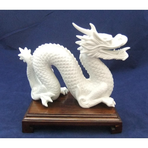 168 - Finely detailed, white fired ceramic dragon (unmarked) on chinese wood plinth,

21 cm long