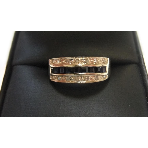 438 - 9ct yellow imported gold band ring with 9 square cut sapphires with a band of diamonds on either sid... 