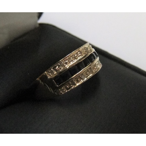 438 - 9ct yellow imported gold band ring with 9 square cut sapphires with a band of diamonds on either sid... 