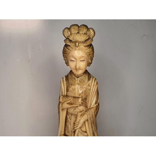 115 - Meiji period, Japanese carving of Geisha carrying a flower.  21 cm tall