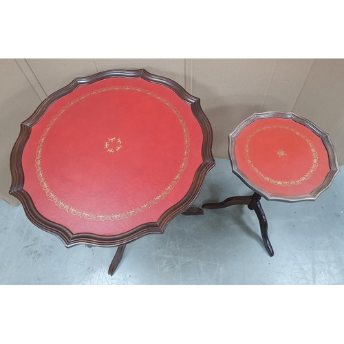 523 - Two small red leather topped side tables on tri-pod feet (2)