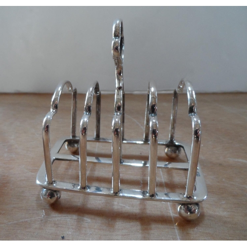 25 - Four pieces of British Edwardian silver including a small 4-part toast rack (4)