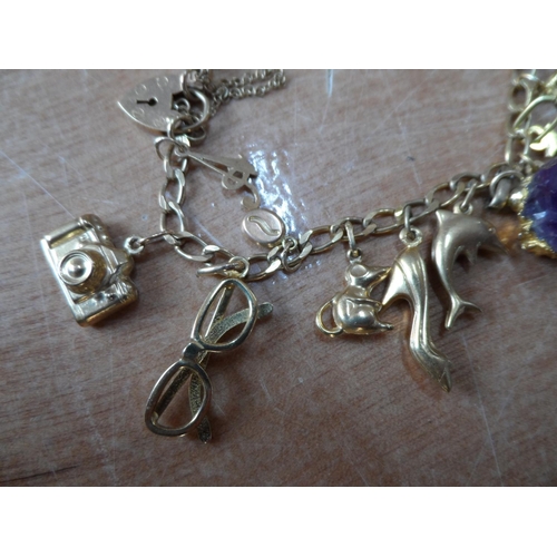 46 - Ladies 9ct yellow gold charm bracelet with approx 22 gold charms, some stamped, some unmarked,

23.7... 