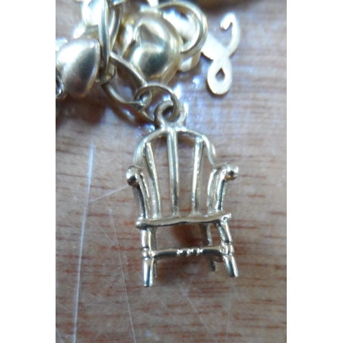 46 - Ladies 9ct yellow gold charm bracelet with approx 22 gold charms, some stamped, some unmarked,

23.7... 