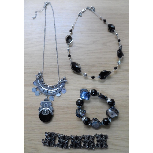 69 - Three small trays of costume jewellery to include a silver coloured charm bracelet etc (Qty)