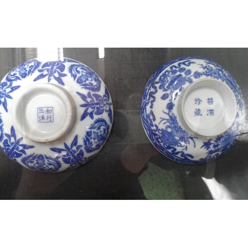 143 - Two gilt framed pictures, one containing two Chinese blue & white signed bowls together with another... 
