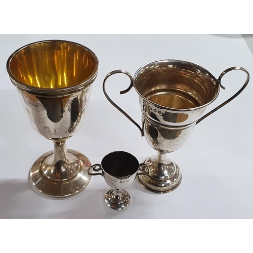 16 - A miniature silver and a slightly larger silver two-handled silver trophy together with a silver egg... 