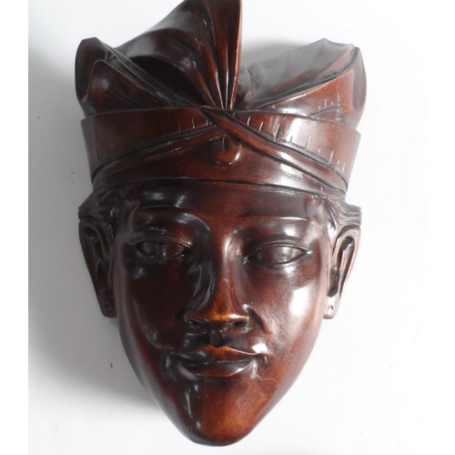 70 - Pair of carved south east Asian wooden face masks together with an African hardwood carving (3)