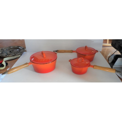 350 - Collection of cast iron, lidded orange cooking pans with wooden handles in descending size (3)