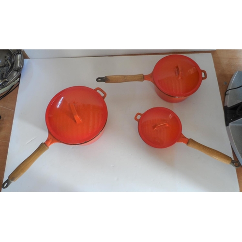 350 - Collection of cast iron, lidded orange cooking pans with wooden handles in descending size (3)