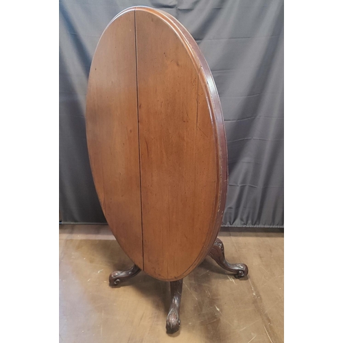 901 - A late Georgian oval tilt-top dining table seated on an ornate pedestal base with castors