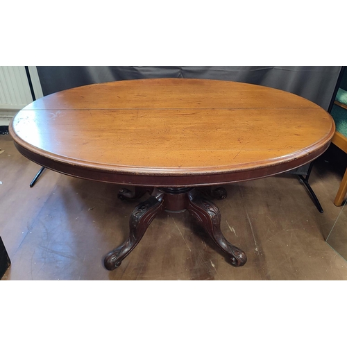 901 - A late Georgian oval tilt-top dining table seated on an ornate pedestal base with castors