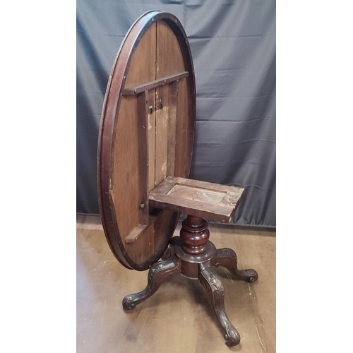 901 - A late Georgian oval tilt-top dining table seated on an ornate pedestal base with castors