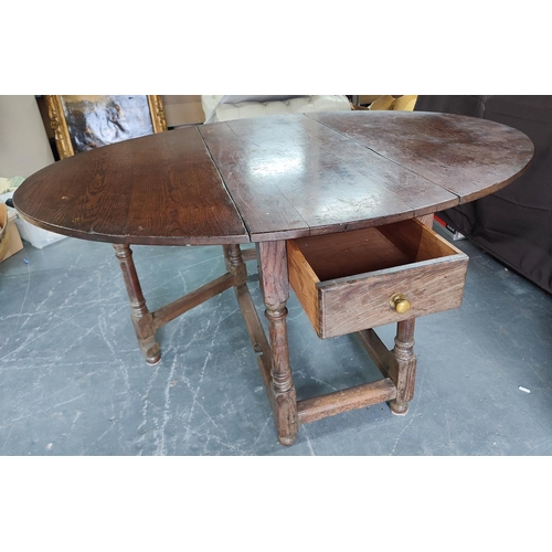 905 - A round drop-leaf and gate-leg dining table with drawer