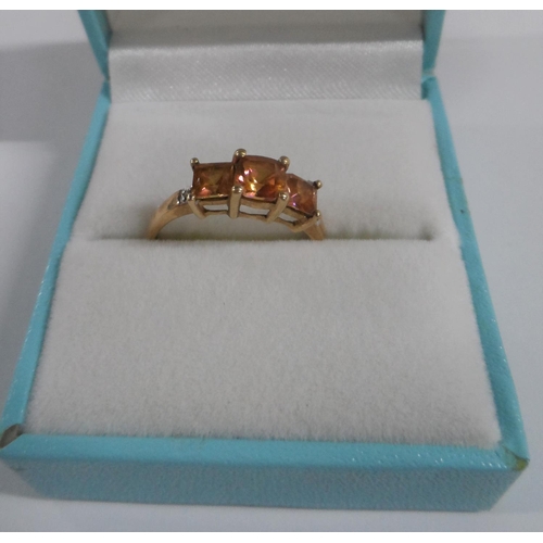 31 - 9ct yellow gold ring inset with 3 square cut orange semi precious stones with small diamonds to the ... 