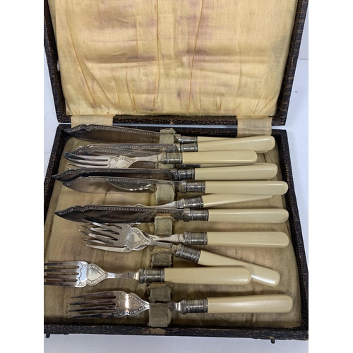 299 - Box of old silver plate items including a pair of Georgian style candle sticks, cased fish knives et... 