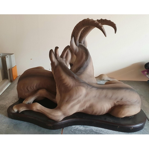 83 - Indistinctly signed, large ceramic sculpture of an Ibex with her young at rest on a wood plinth,

45... 