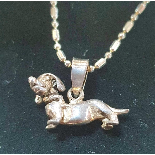 63 - Two silver necklaces with Sausage dog pendants together with a silver necklace with a silver Teddy B... 