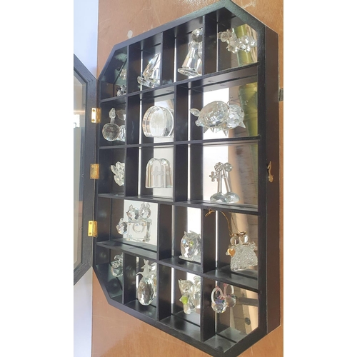 112 - Swarovski small crystal glass figurines and animals in a display cabinet