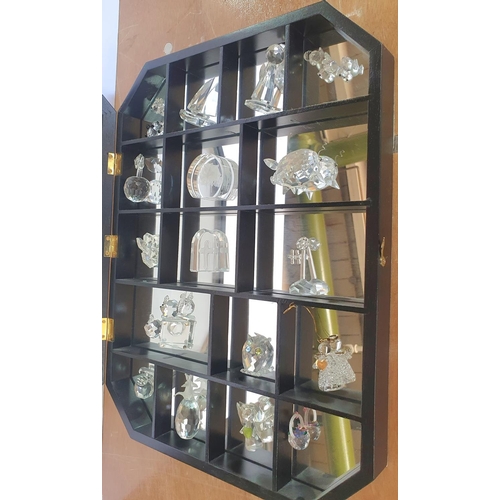 112 - Swarovski small crystal glass figurines and animals in a display cabinet