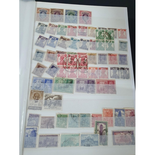 202 - Blue stamp album containing a large collection of used & mint stamps including 19thC India and Jamai... 