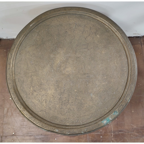 541 - Brass engraved top Moorish table with ornate wooden base

71cm diameter