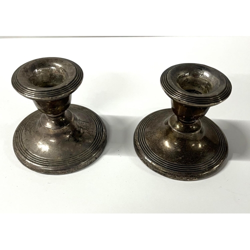 17 - Pair of dwarf silver weighted candlesticks