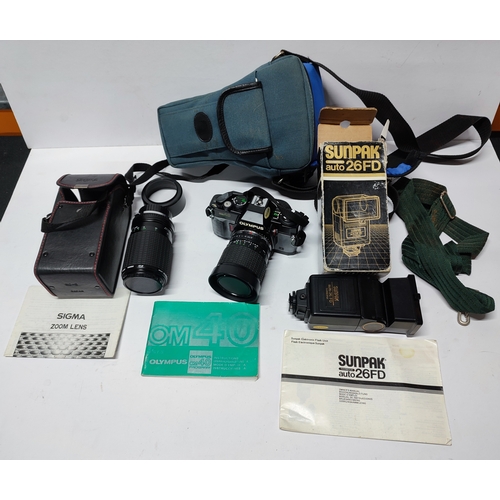 196 - An Olympus OM40 Program camera, a Sigma zoom lens and a Sunpak Auto 26D flash, all with cases (Qty)