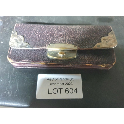 604 - Old leather purse with hallmarked silver lock and edgings